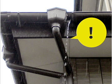 雨が雨どいから漏れている様子